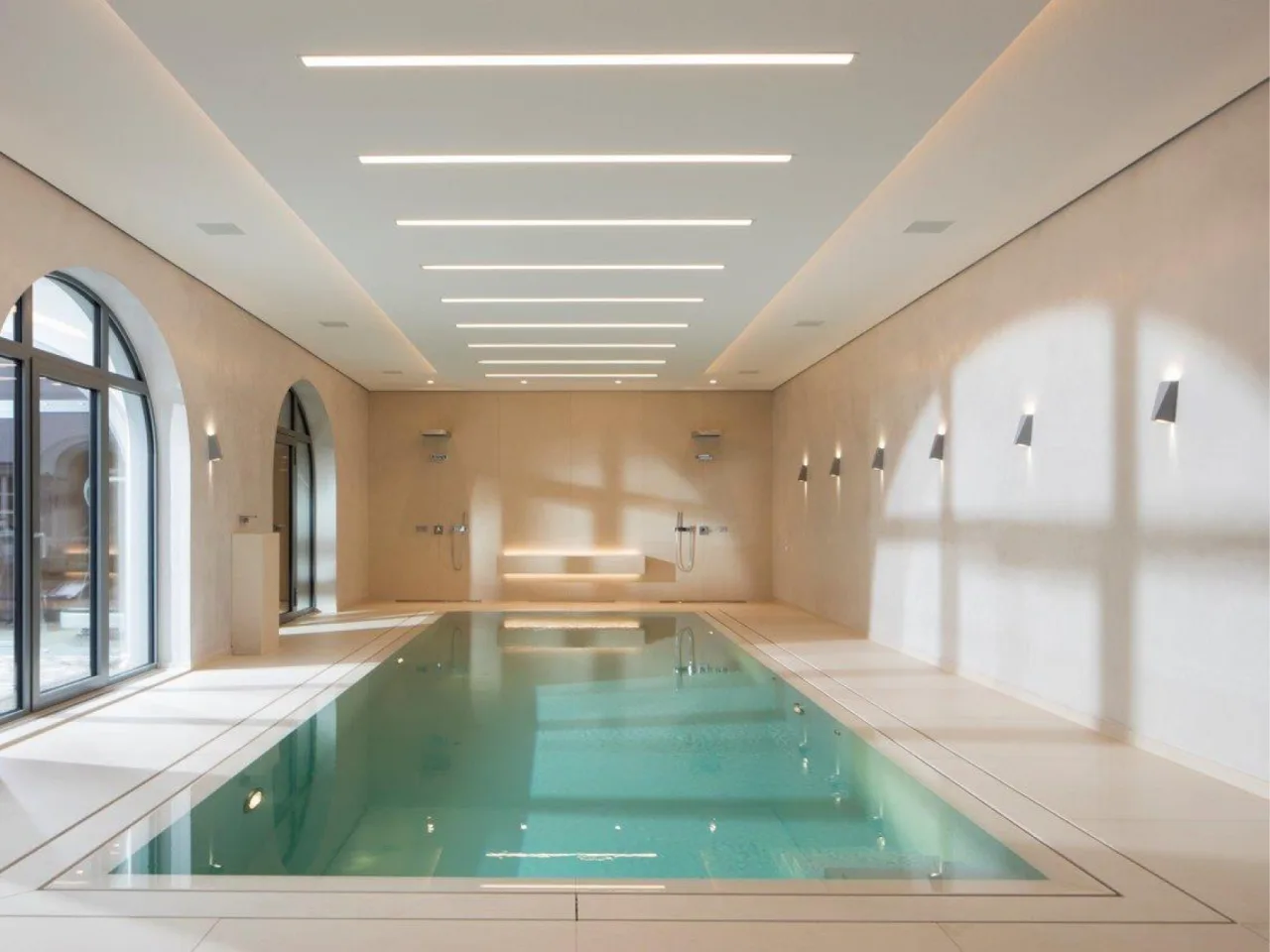 Innen liegendes Becken in heller Halle mit Lichtbändern an der Decke und Rundbogenfenstern