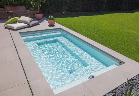Kleines Becken mit Sitzbank im Wasser, direkt am Rasen gelegen