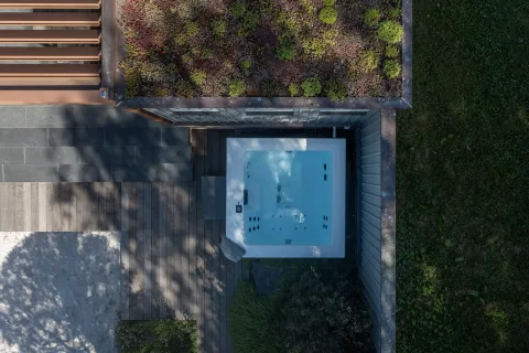 Luftbild eines Whirlpools auf einer Holzterrasse neben einem Gründach